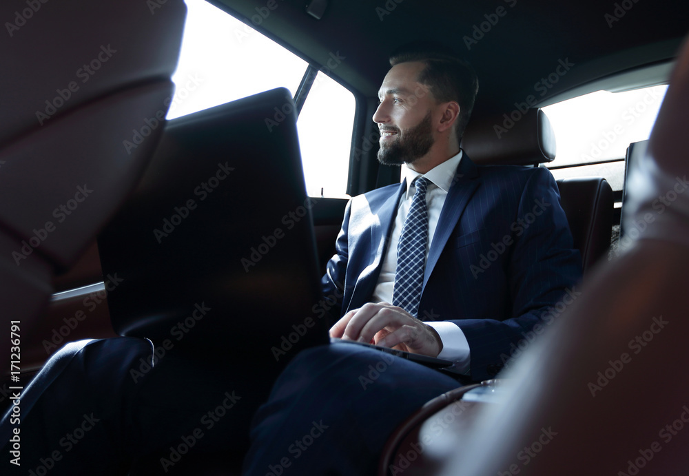 businessman working with laptop and looking out the window of a car businessman working with laptop and looking out the window of a car
