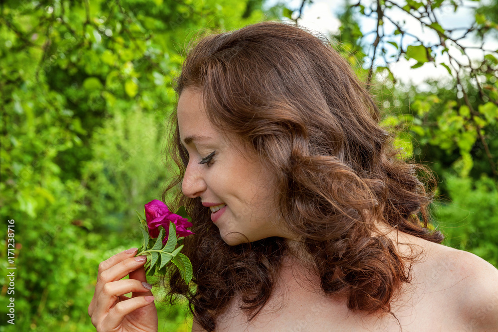 Girl with the flower in her hand in a park Girl with the flower in her hand in a park