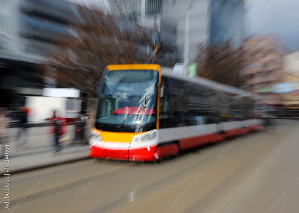 red tram on the street under blurred motion