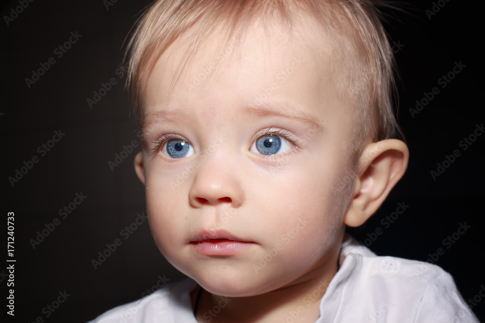 Closeup portrait of adorable child isolated on dark background