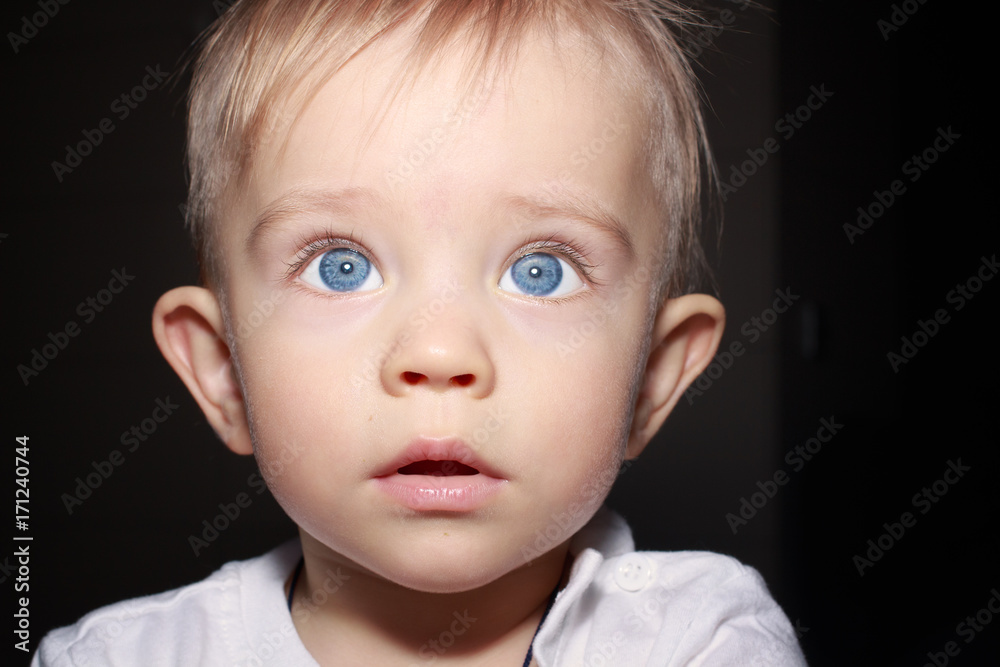 Closeup portrait of adorable child isolated on dark background Closeup portrait of adorable child isolated on dark background
