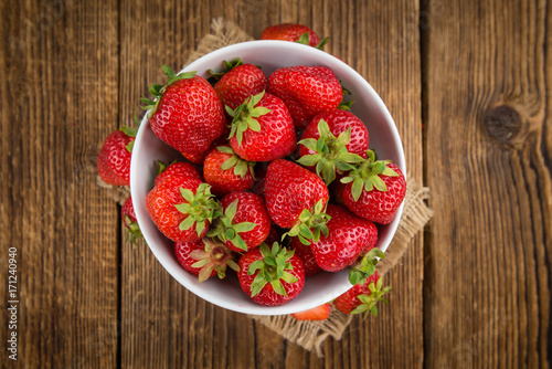 Portion of Strawberries on wooden background  selective focus