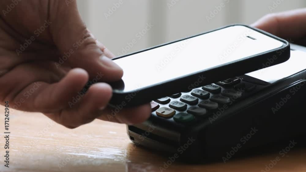 Close-up shot of person using NFC technology on smart phone to pay