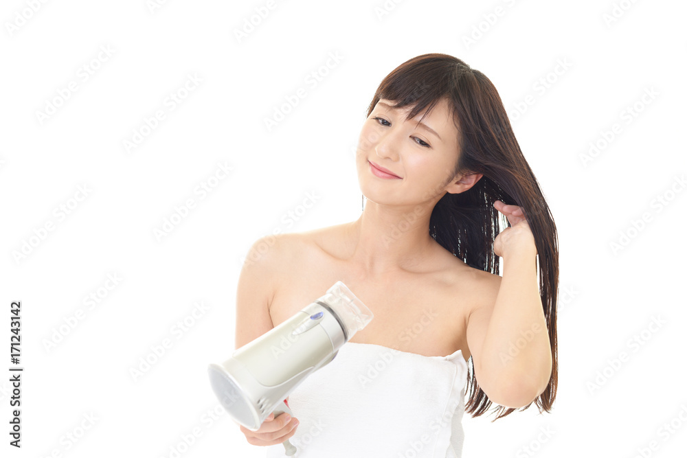 ヘアードライヤーで髪を乾かす女性 ヘアードライヤーで髪を乾かす女性