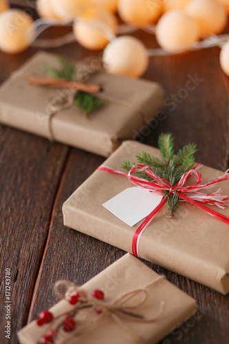 Christmas gift boxes and fir tree branch on wooden table