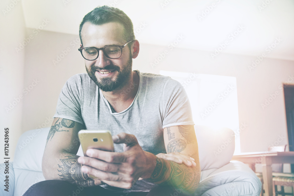 smiling man with smart phone sitting on couch smiling man with smart phone sitting on couch
