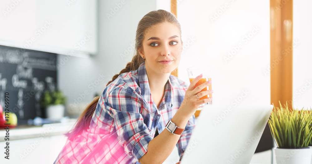Beautiful woman cooking cake in kitchen standing near desk Beautiful woman cooking cake in kitchen standing near desk