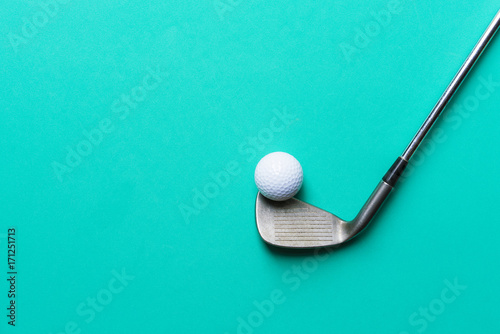 Fototapeta piłeczka golfowa i kij golfowy na zielonym tle