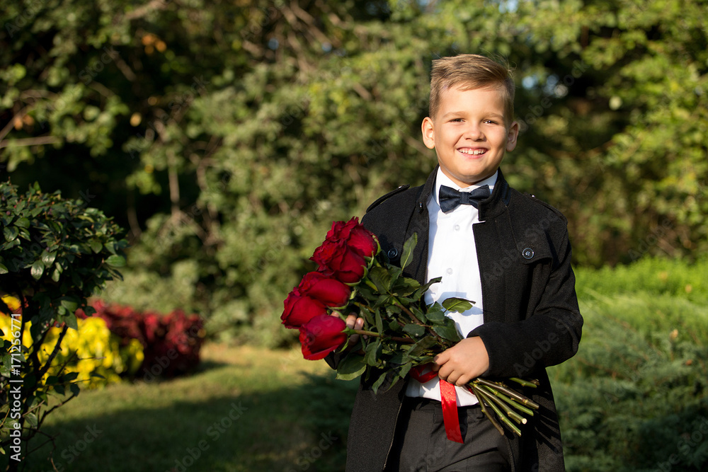 Portrait of a boy, a schoolboy with a bouquet of flowers in the garden. Portrait, childhood, age. Portrait of a boy, a schoolboy with a bouquet of flowers in the garden. Portrait, childhood, age.
