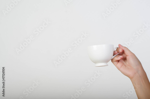 Close up of woman hand holding a cup of coffee isolated on white background.