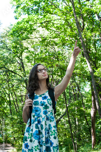 Girl tourist in the forest raised her hand up