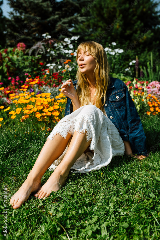 Blonde hair beautiful girl on the flower field