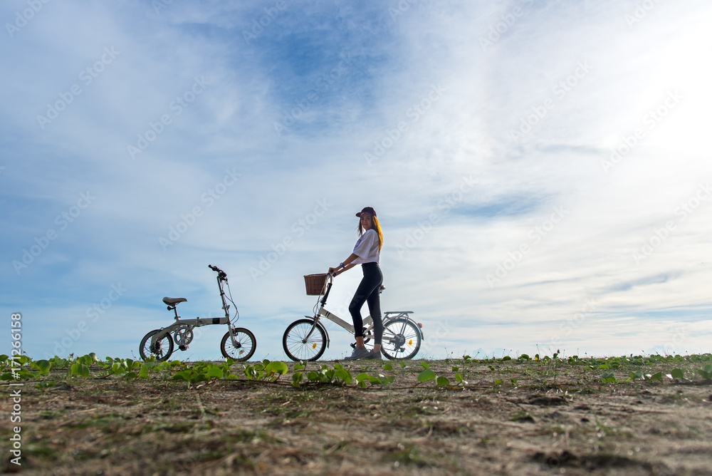 Smiling woman enjoy and relax with bicycle riding on beach sand having fun and happy, blue sky background. Lifestyle Concept. Smiling woman enjoy and relax with bicycle riding on beach sand having fun and happy, blue sky background. Lifestyle Concept.