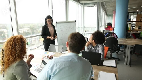 Meeting room in modern office, presentation of project. Businesswoman showing project objectives on diagram. photo