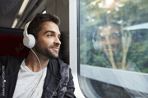 Guy enjoying travel by train, smiling