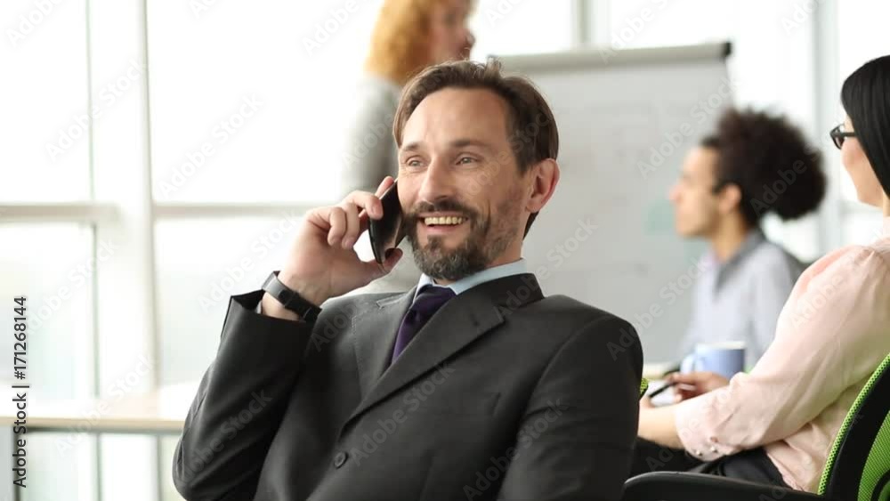 Close up view of businessman spinning on chair in the meeting room. Teamwork of colleagues, chief talking on phone sitting on spinning chair. Close up view of businessman spinning on chair in the meeting room. Teamwork of colleagues, chief talking on phone sitting on spinning chair.