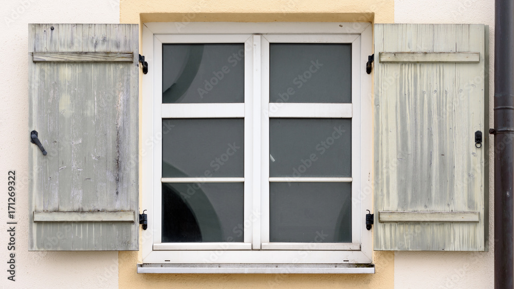 Fototapeta premium Sprossenfenster mit hölzernen Fensterläden