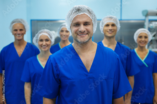 Handsome doctor being proud of his team