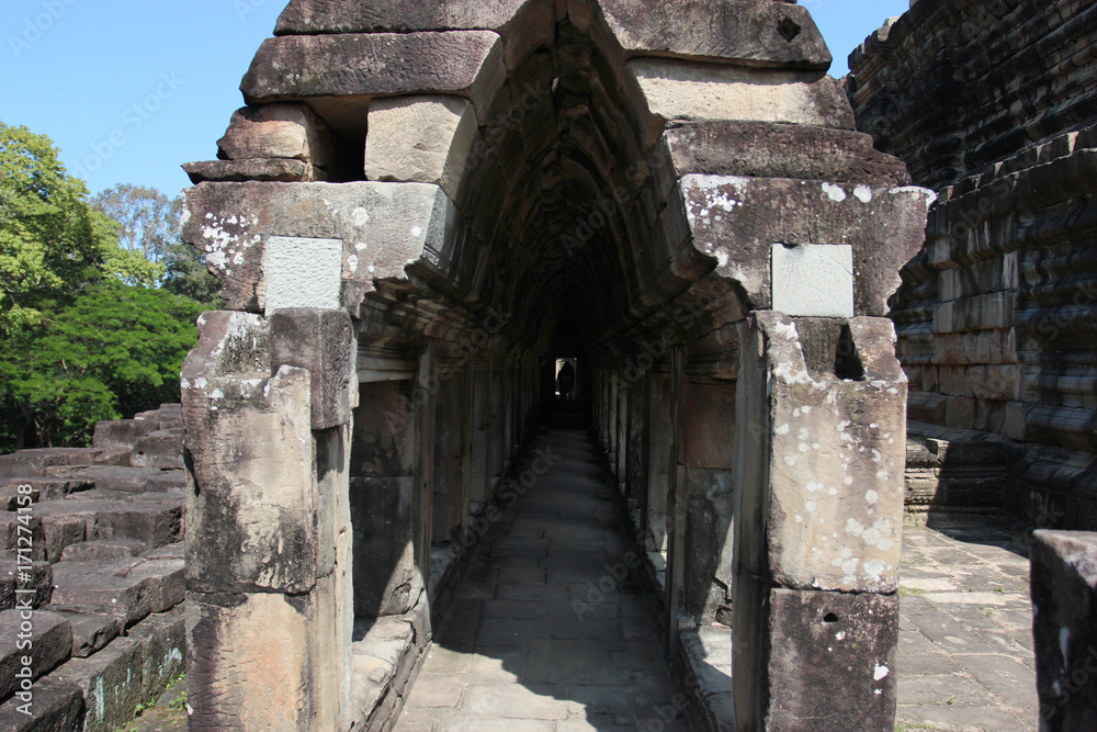 Fototapeta premium Ruins and walls of an ancient city in Angkor complex, near the ancient capital of Cambodia - Siem Reap