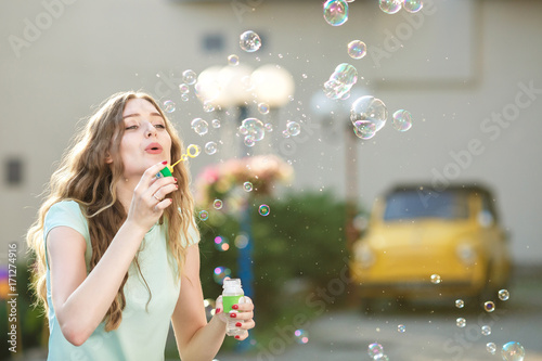 Valokuva happy woman blowing soap bubbles