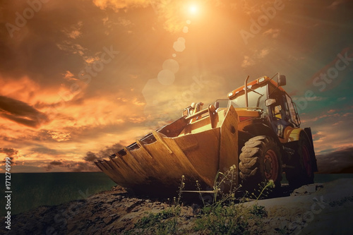 Fotografie Yellow tractor on sky background