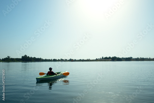 Boy in life jacket on green kayak