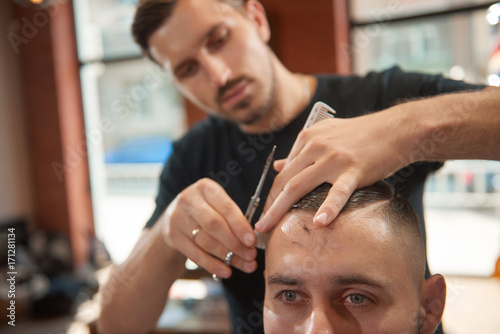 Cropped shot of a young man getting a haircut at the barbershop. 