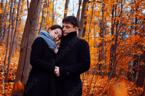 Young couple in autumn Park. Cute guy and a girl walking together