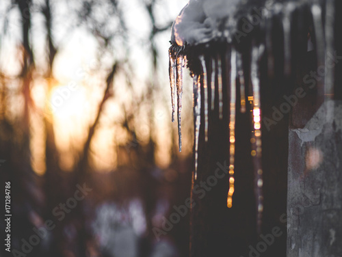 Beautiful Photo Winter, icicles hanging from the roof, sunset