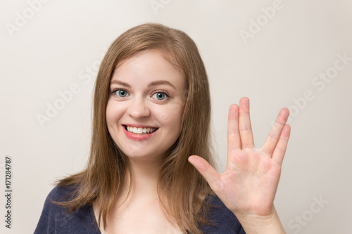 Young caucasian woman shows vulcan greeting