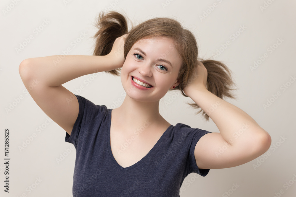 Young, happy caucasian woman smiles and plays with her hair Young, happy caucasian woman smiles and plays with her hair