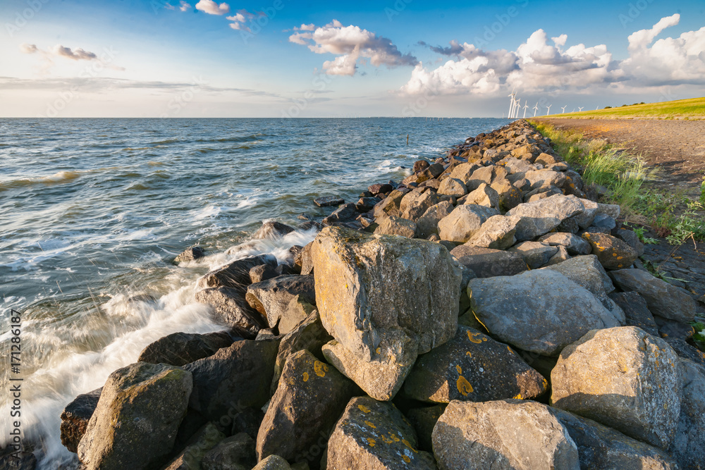 The polder dike with stone bollards along the Ijsselmeer at Flevoland