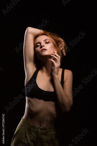 Sad blond woman portrait against black background. Anorexia