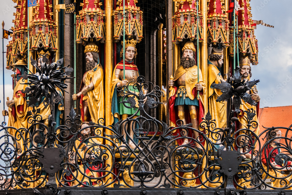 Fototapeta premium Detail of Beautiful fountain (Schoner Brunnen) and statue. 19 meters high Schoner Brunnen - 14th-century fountain located on Nuremberg's main market, built by Heinrich Beheim. Nuremberg, Germany.