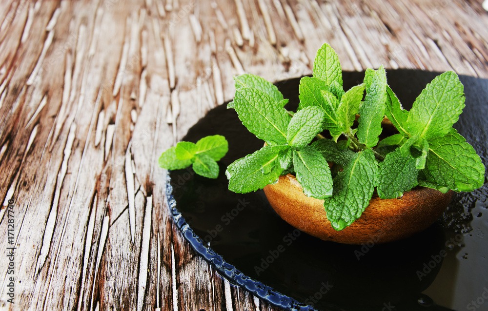 Fresh mint in a wooden bowl, selective focus