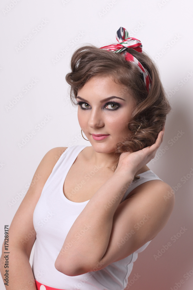 Pinup beautiful girl in white and with curly hair poses in white studio Pinup beautiful girl in white and with curly hair poses in white studio