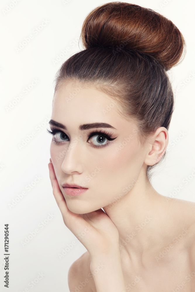 Portrait of young beautiful slim girl with cat eyes make-up and hair bun Portrait of young beautiful slim girl with cat eyes make-up and hair bun