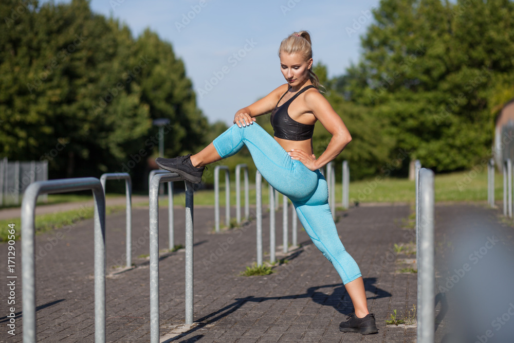 sportliche Frau dehnt ihre Beine und Po