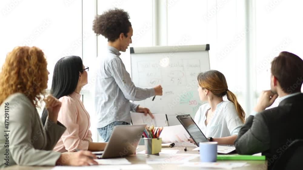 Negotiations of business team in the modern office. Employees discussing current project, working with chart. Negotiations of business team in the modern office. Employees discussing current project, working with chart.