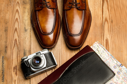 Zapatos marrones de hombre con cámara de fotos y mapa