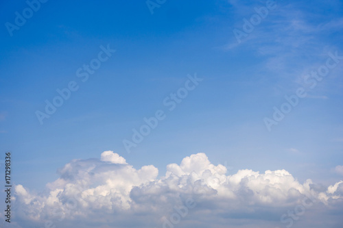 Fluffy cumulus clouds on light blue sky