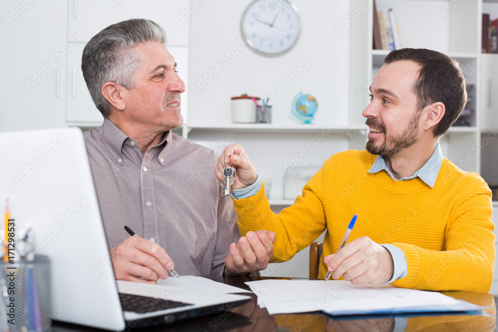 Obraz premium Mature man and agent sign rental agreement