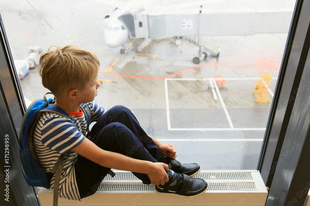 little boy looking at planes travel in airport