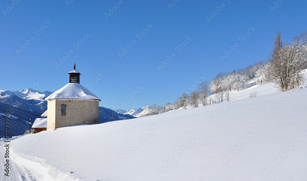 chapelle en bas d'une colline enneigée en montagne 