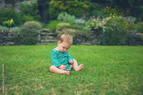 Little baby sitting on a lawn © LoloStock