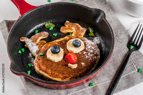 Funny food for Christmas. Kids breakfast pancake decorated like reindeer, with hot chocolate with marshmallow, white table copy space top view