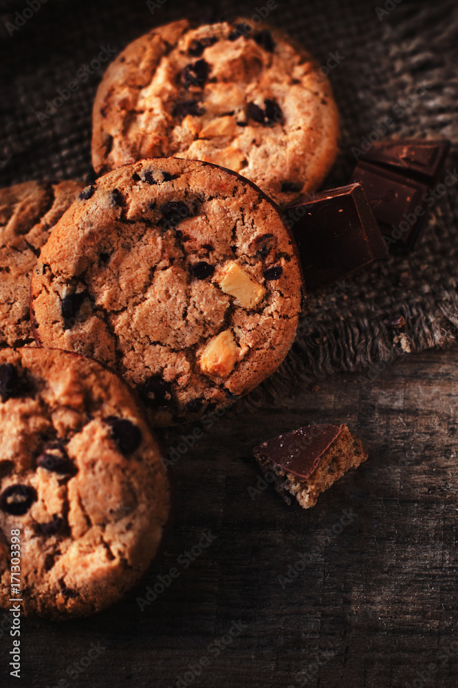 Chocolate chip cookie on burlap and rustic wooden table. Freshly baked choco cookie close up Chocolate chip cookie on burlap and rustic wooden table. Freshly baked choco cookie close up