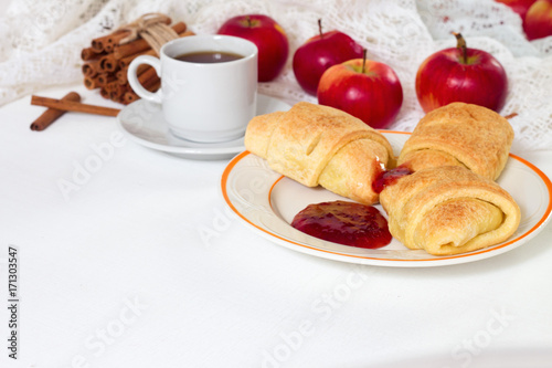 Breakfast with croissants, honey and apples and cup of espresso coffee on white rustic wooden background, top view