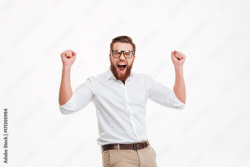 Happy young bearded man showing winner gesture. Happy young bearded man showing winner gesture.