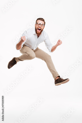 Valokuva Cheerful young bearded man jumping